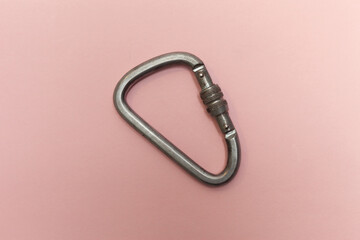 One industrial carabiner on a pink background