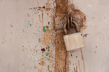 gray old metal lock on rusty doors