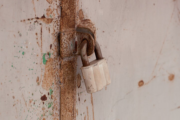 gray old metal lock on rusty doors
