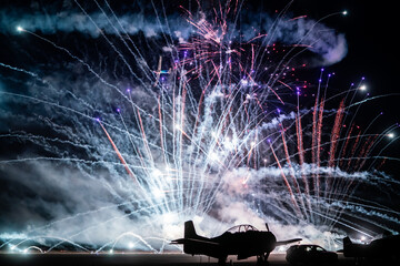 Obraz na płótnie Canvas Zabytkowy samolot na tle fajerwerków podczas pokazów lotniczych 