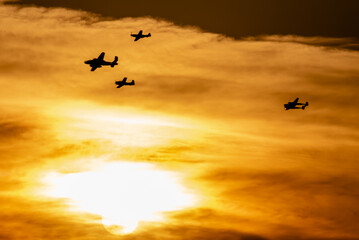 Lot formacji czterech samolotów na pokazach lotniczych na tle słońca - obrazy, fototapety, plakaty