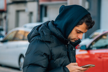 man in coat on the street with mobile phone