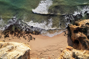 Beach and waves from top view. Turquoise water background. Summer seascape from air. Portugal Lagos Algarve. Travel concept and idea