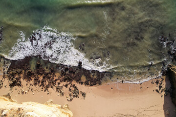 Beach and waves from top view. Turquoise water background. Summer seascape from air. Portugal Lagos Algarve. Travel concept and idea