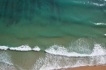 Obraz na płótnie Canvas Beach and waves from top view. Turquoise water background. Summer seascape from air. Portugal Lagos Algarve. Travel concept and idea