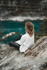 Young woman in mountains river and autumn forest; traveller in beautiful nature. Siberian nature - Altai mountains and turquoise Katun in autumn cloudy evening