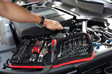 Mechanic examining and maintenance the engine a vehicle car hood