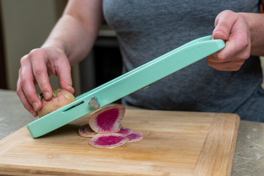 Woman slicing on a mandolin 