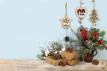 Empty rustic table with live Christmas tree in eco bag and homemade gift boxes and...