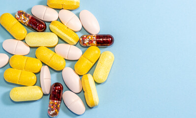 scatter different colors shapes pills tablets capsules,surgical gloves,tequila glass with water.prescription take medicine,vitamins antibiotics probiotics pain .doctor woman hand in glove hold pill