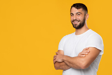 Cheerful friendly confident mature caucasian man in white t-shirt with crossed arms on chest