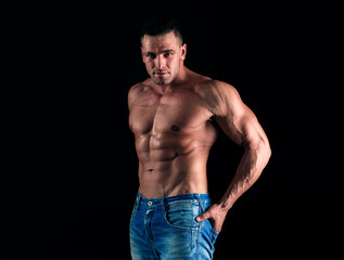 Fototapeta premium Sporty man on black. Handsome fitness young bodybuilder with naked torso.