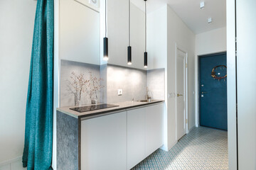 Minimalistic compact kitchen in a small apartment with elements of concrete, black and white