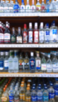 Abstract blur image of supermarket background. Defocused shelves with bottles of alcohol, vodka, cognac, brandy, wine, champagne and beer. Store. Retail industry. Ban. Environmental price. Inflation