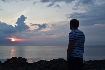 Fototapeta premium Landscape photo of person watching sea at sunset