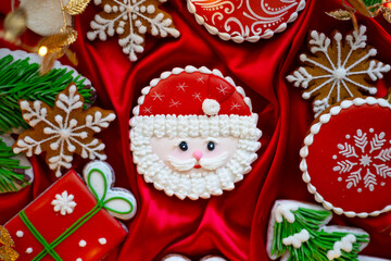 Fototapeta na wymiar Banner for Christmas and New Year gingerbread cookies Santa Claus, snowflakes, Christmas trees, garlands on red silk fabric background