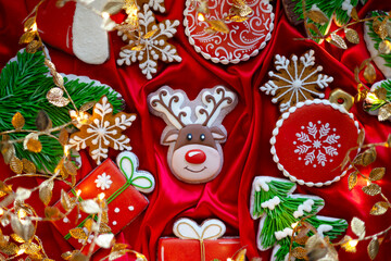 Banner for Christmas and New Year gingerbread cookies deer, Santa Claus, snowflakes, Christmas trees, garlands on red silk fabric background