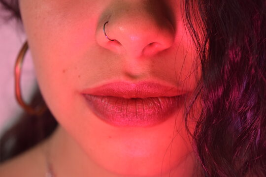 Labios de mujer joven en luz violeta 