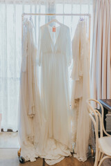 wedding dress hanging on a hanger on a boutique room 
