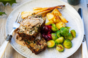 Vegetarian Christmas dinner with nut roast, mushroom sauce, roast parsnips and brussel sprouts