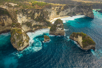 Aerial shot at sea with turquoise water and rocks. Atuh beach, Nusa Penida, Bali, Indonesia.