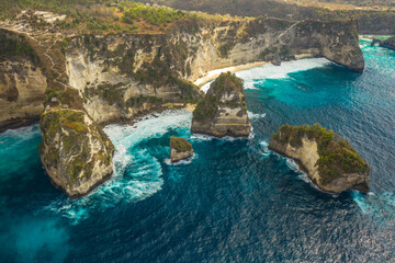 Naklejka premium Aerial shot at sea with turquoise water and rocks. Atuh beach, Nusa Penida, Bali, Indonesia.