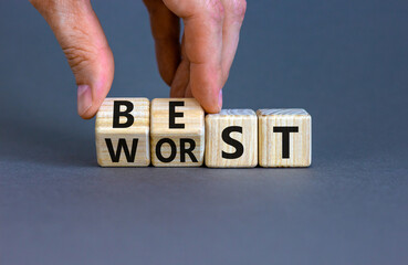 Best or worst symbol. Businessman turns wooden cubes and changes the word best to worst. Beautiful...