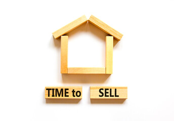 Time to sell house symbol. Concept words 'Time to sell' on wooden blocks near miniature house. Beautiful white background, copy space. Business and time to sell house concept.