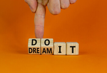 Dream and do it symbol. Businessman turns cubes and changes words 'dream it' to 'do it'. Beautiful orange table, orange background. Business and Dream and do it concept. Copy space.