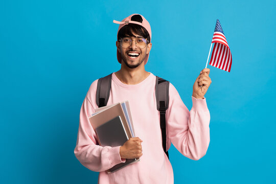 Smiling indian guy student showing flag of US