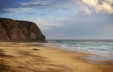 A rock formation on sandy beach