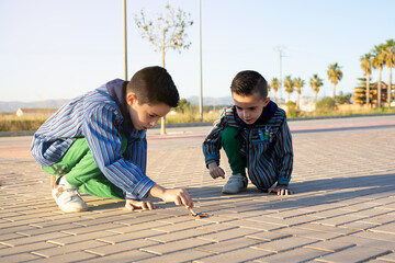 Two valencian brothers wearing a valencian fallas dress and playing with firecrackers