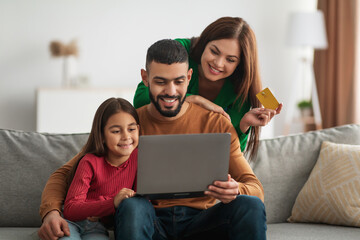 Arabic family using laptop computer and credit card at home