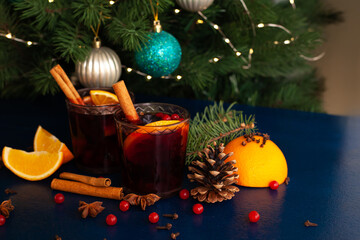 Christmas mulled wine with cinnamon stick, orange, anise and cloves on a blue background. Winter...
