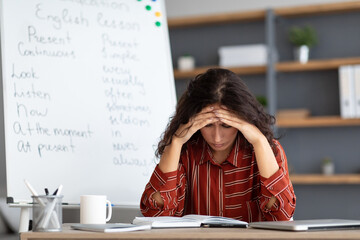 Tired teacher sitting at desk thinking about problems