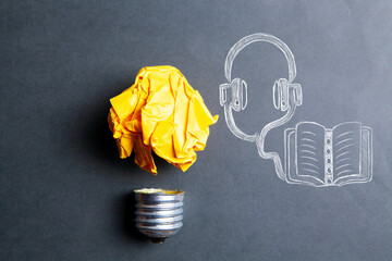 light bulb and drawn book and headphones. audiobook concept