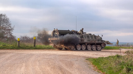 a British Army Challenger Armored Repair and Recovery Vehicle (CRARRV) throws out clouds of diesel smoke on a military training exercise, salisbury plain wiltshire UK