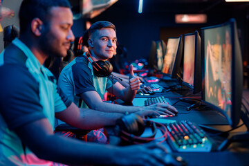 Caucasian young man happy with his game and showing thumbs-up gesture during participation in...