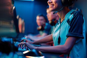 Cropped shot of cheerful African woman in headphones involved in online video game in cyber sports club