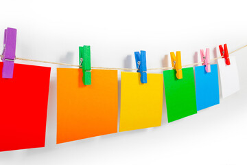 Photo of various paper notes hanging on rope with bee shaped pins on white background.