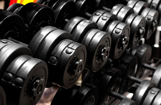 Photo of black colored plastic dumbbell row standing in sports equipment store.