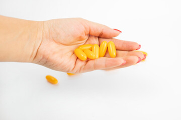 girl holding medication capsules yellow in hands for anesthesia and treatment on an isolated white background