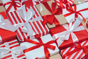 Cropped shot close up of many wrapped gift boxes tied with satin ribbons