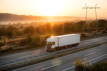 Big powerful truck along the highway. Highway transportation with hills and montains in the...