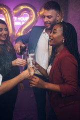 Friends celebrate New Year's Eve while drinking champagne
