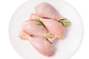 Top view of a four-piece raw whole chicken leg on a white plate on a white isolated background. Fresh chicken legs close-up isolade.