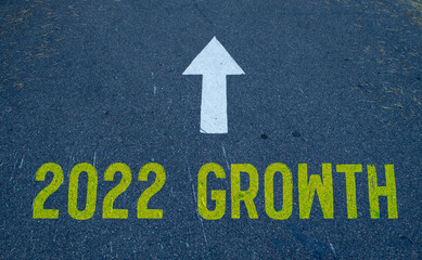 New year 2022 growth and white arrow written on asphalt road