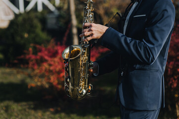 A man in a suit, saxophonist, musician plays the saxophone with a microphone. Close-up portrait.