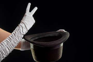 Hand gestures. The magician shows tricks with a hat. Black background