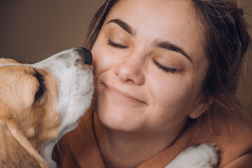 a girl hugs and kisses a dog
